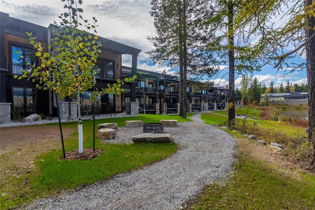 surrounding community featuring an outdoor fire pit and a yard