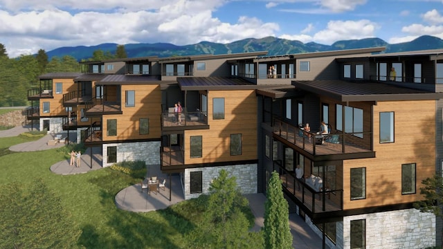 exterior space featuring a mountain view, a balcony, a lawn, and a patio area