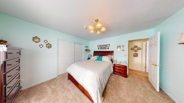 bedroom featuring a closet, an inviting chandelier, and light colored carpet