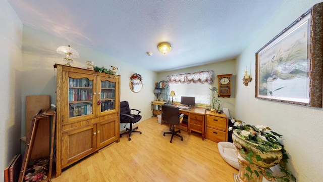 office with a textured ceiling and light wood-type flooring