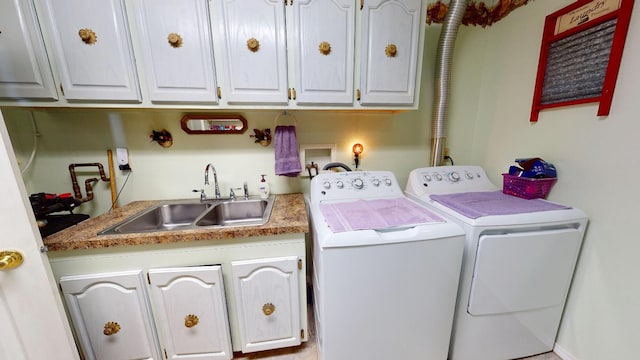 laundry room with hookup for a washing machine, washing machine and dryer, cabinets, and sink