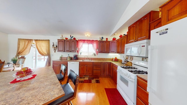 kitchen with white appliances, sink, and light wood-type flooring