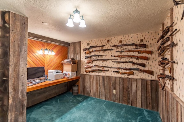 interior space featuring wooden walls, dark carpet, and a textured ceiling