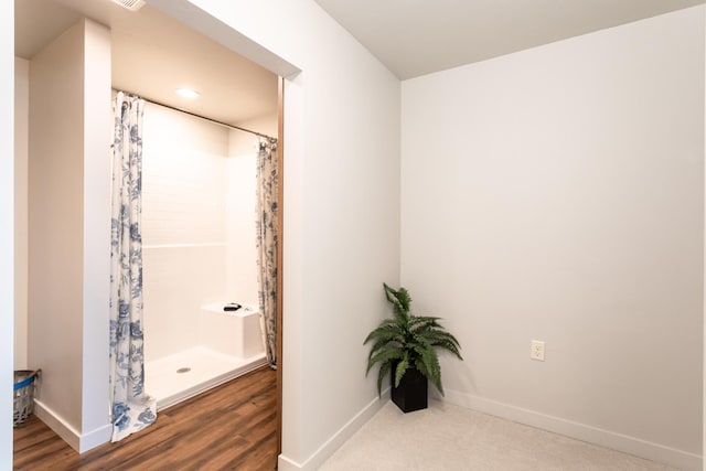 bathroom with wood-type flooring and curtained shower