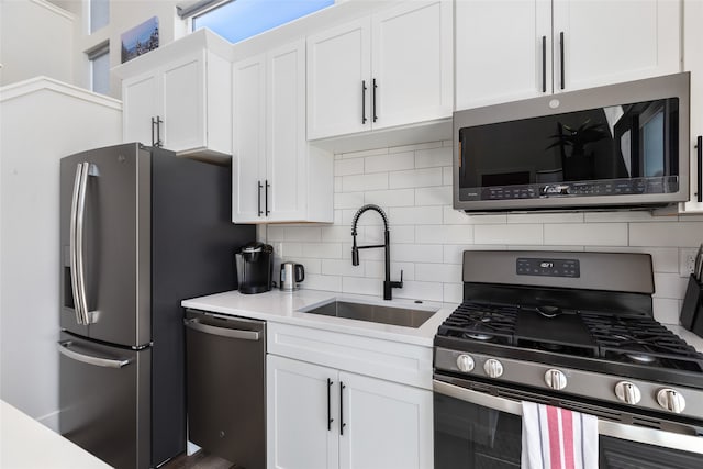 kitchen featuring tasteful backsplash, white cabinetry, appliances with stainless steel finishes, and sink