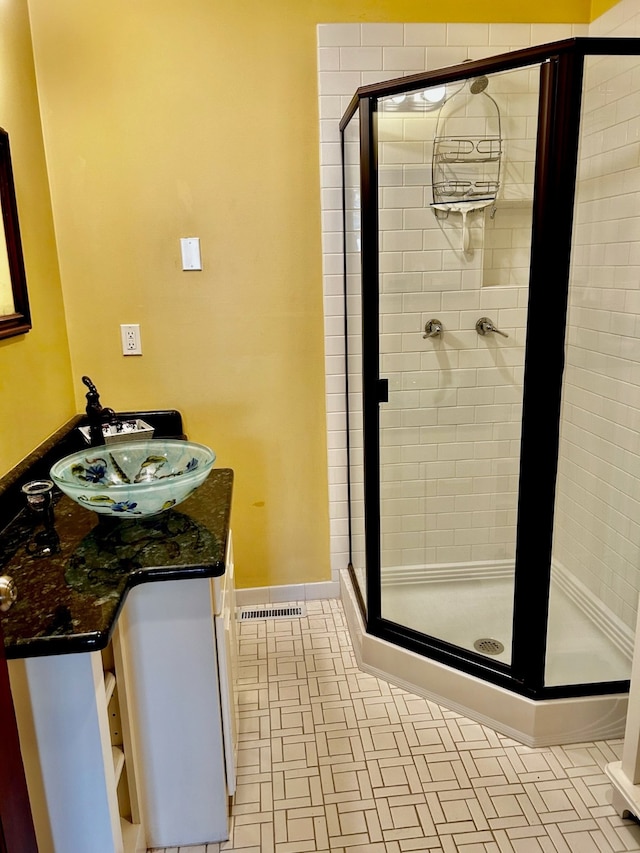 bathroom featuring vanity, tile floors, and a shower with shower door