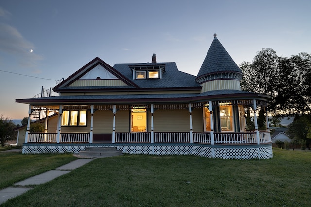 victorian-style house featuring a porch and a yard