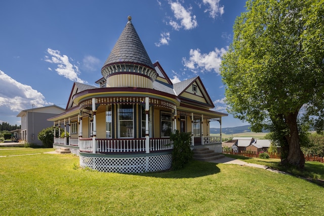 back of house featuring covered porch and a yard