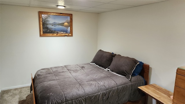 bedroom with carpet floors and a paneled ceiling