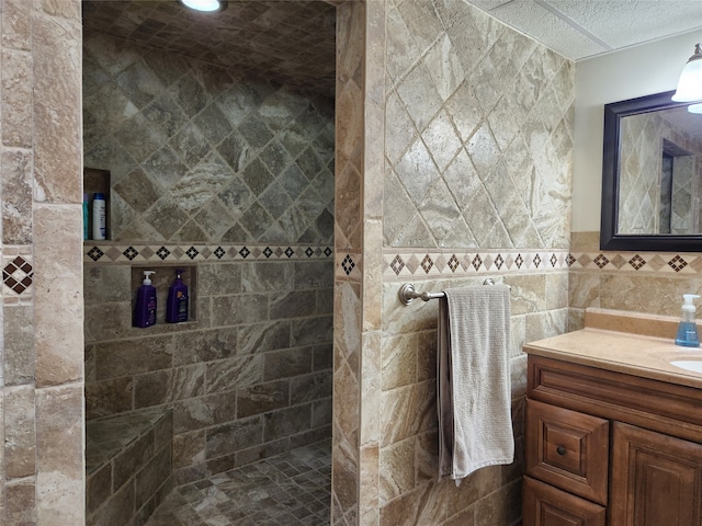 bathroom with oversized vanity, tile walls, and a tile shower