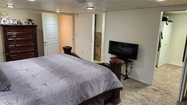 carpeted bedroom featuring a drop ceiling