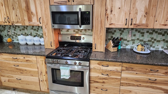 kitchen featuring backsplash, stainless steel appliances, and dark stone counters