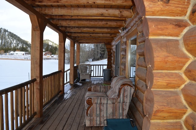 snow covered deck featuring a mountain view