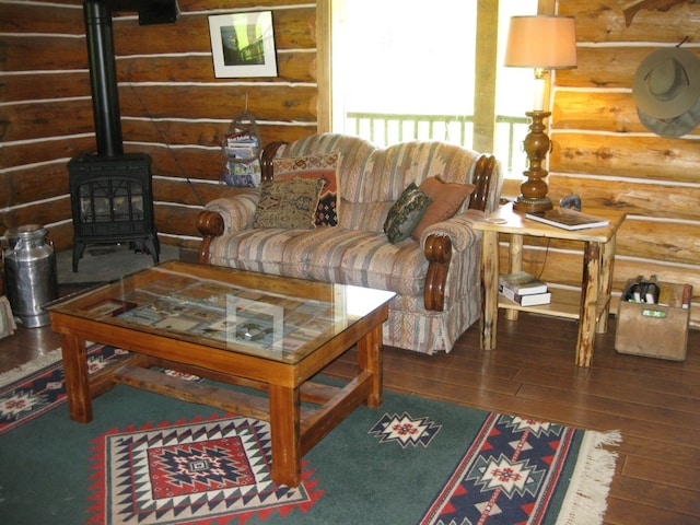 living room with hardwood / wood-style flooring, a wood stove, and log walls