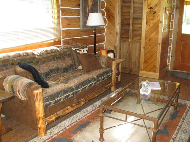 living room with log walls, hardwood / wood-style flooring, and a wealth of natural light