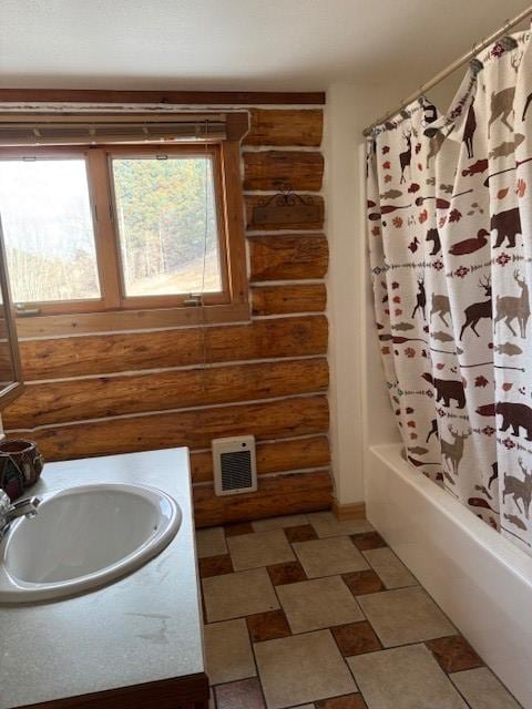 bathroom featuring log walls, shower / bath combination with curtain, and vanity