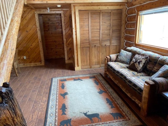 living room featuring hardwood / wood-style flooring and rustic walls