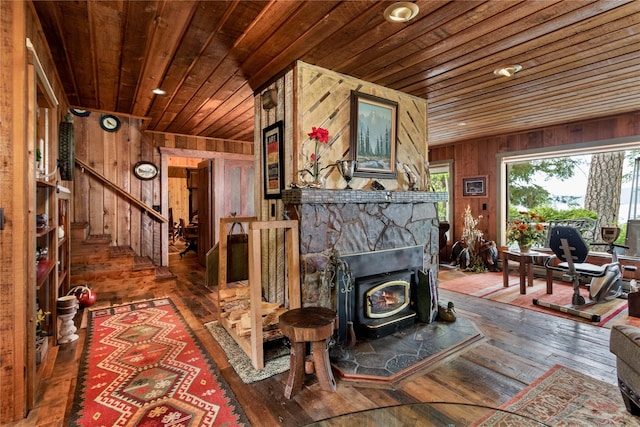 living room with dark hardwood / wood-style floors, a wood stove, wood walls, and wood ceiling