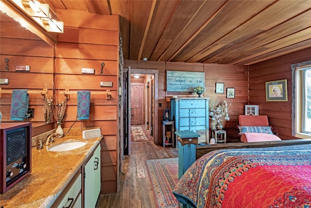 bedroom featuring sink, dark hardwood / wood-style flooring, wooden ceiling, and wood walls