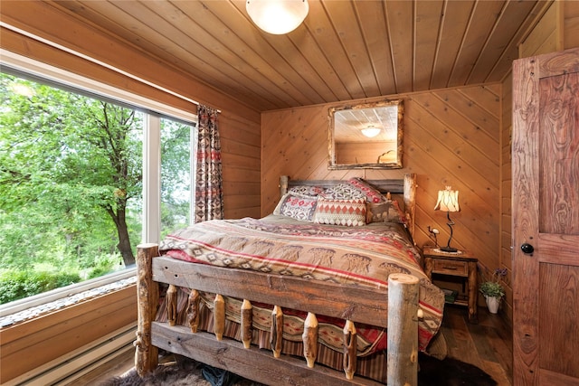 bedroom featuring hardwood / wood-style floors, baseboard heating, wooden ceiling, and wood walls