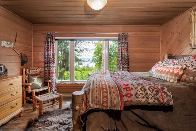 bedroom featuring wooden walls, multiple windows, and wooden ceiling