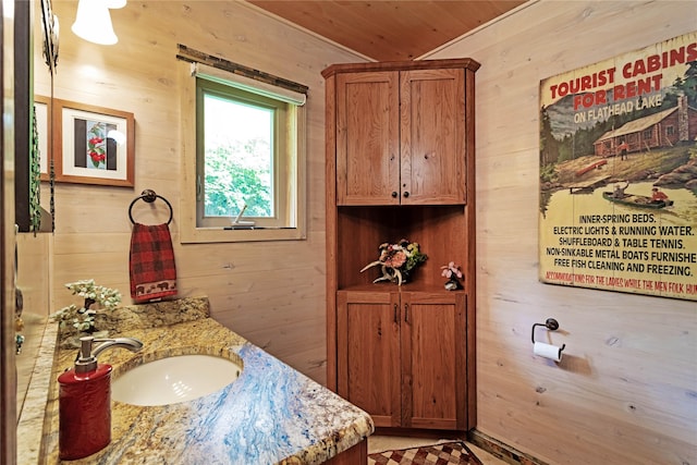 bathroom featuring vanity, wooden ceiling, and wood walls