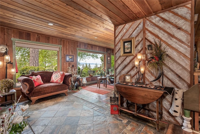 living area with wood walls, wooden ceiling, and vaulted ceiling