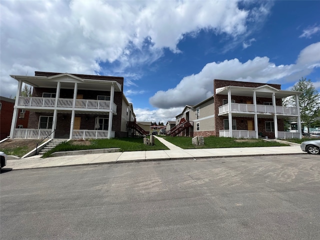 view of front of property with a balcony and a front lawn