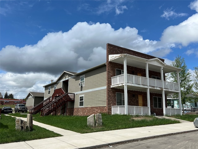 exterior space featuring a balcony and a front lawn