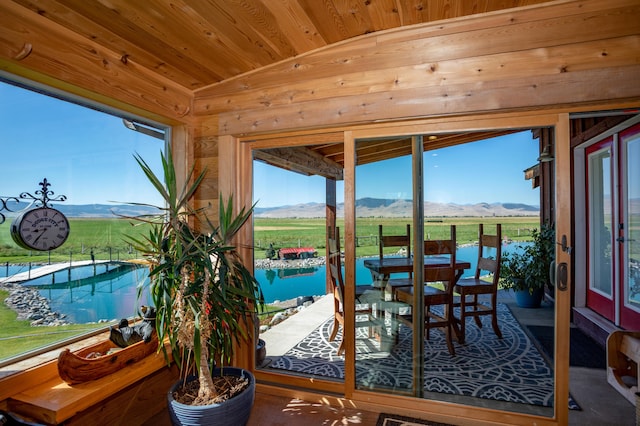 sunroom with wooden ceiling, vaulted ceiling, and a mountain view