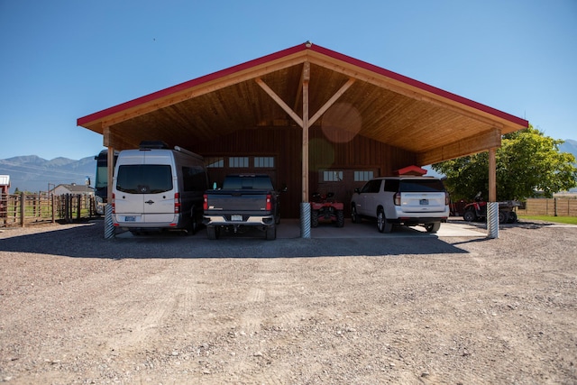 view of vehicle parking featuring a mountain view and a carport