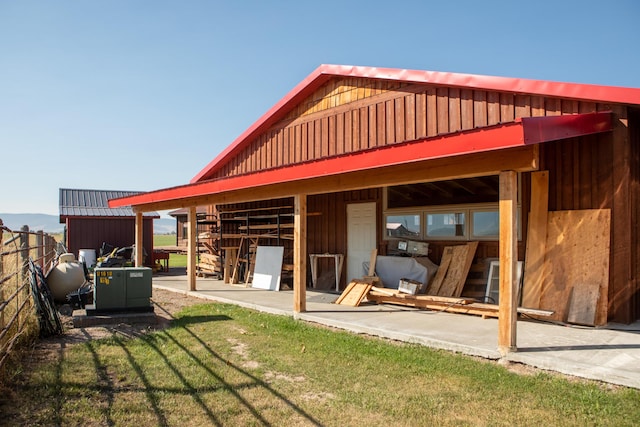 rear view of property with a yard and an outdoor structure