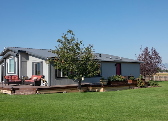 back of property with an outdoor hangout area, a wooden deck, and a lawn