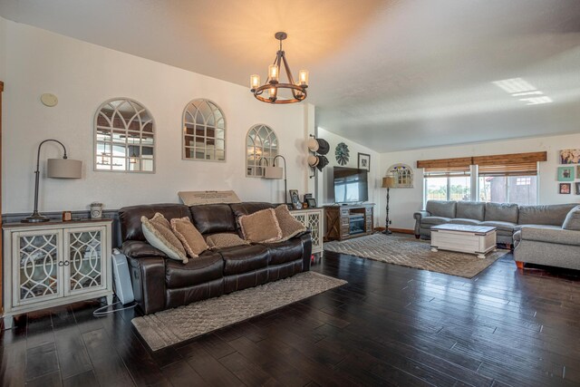 living room featuring dark hardwood / wood-style floors, a notable chandelier, and lofted ceiling