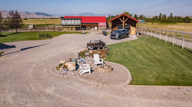 view of yard featuring a mountain view, a rural view, and an outdoor structure