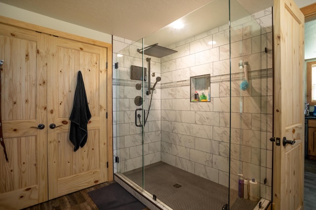 bathroom featuring a shower with shower door and hardwood / wood-style flooring