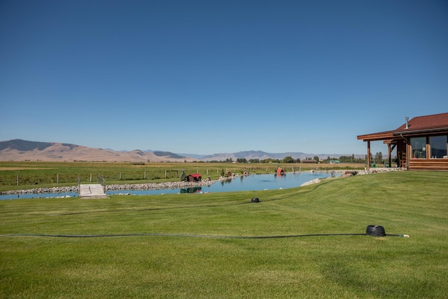 view of nearby features featuring a rural view, a water and mountain view, and a lawn