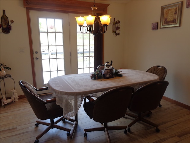 dining room with light hardwood / wood-style flooring and a notable chandelier