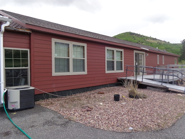 view of side of home with a deck and central air condition unit