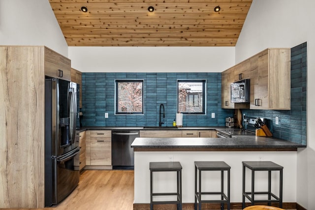 kitchen with wood ceiling, a kitchen breakfast bar, kitchen peninsula, and appliances with stainless steel finishes