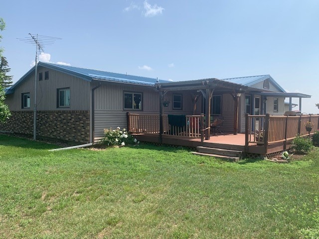 rear view of property featuring a deck and a lawn