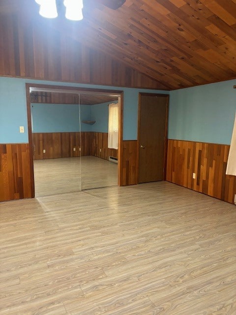 spare room featuring light hardwood / wood-style floors, a baseboard radiator, and wood ceiling