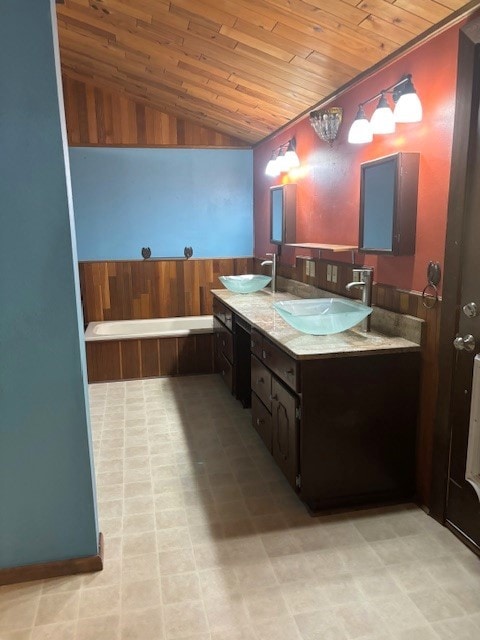 bathroom featuring lofted ceiling, tile floors, dual sinks, vanity with extensive cabinet space, and wood ceiling