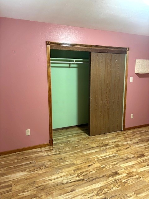 unfurnished bedroom with a closet and light hardwood / wood-style floors