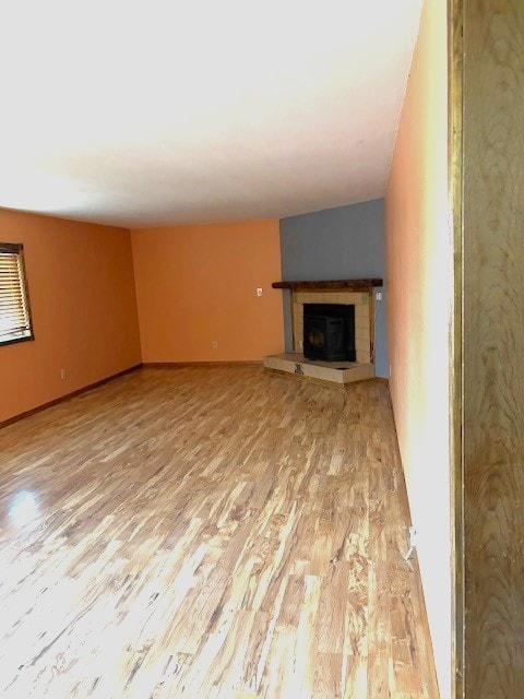 unfurnished living room with light hardwood / wood-style floors and a tile fireplace