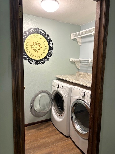 clothes washing area with washing machine and clothes dryer and dark hardwood / wood-style floors