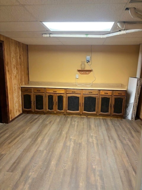 miscellaneous room featuring a drop ceiling and light hardwood / wood-style floors