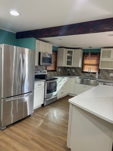 kitchen featuring tasteful backsplash, stainless steel appliances, wood-type flooring, and sink