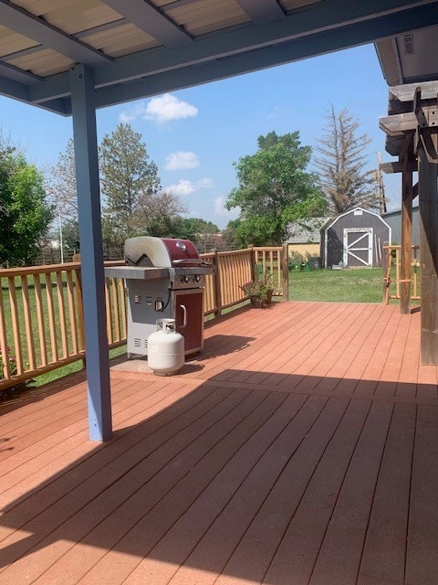 deck with area for grilling and a shed