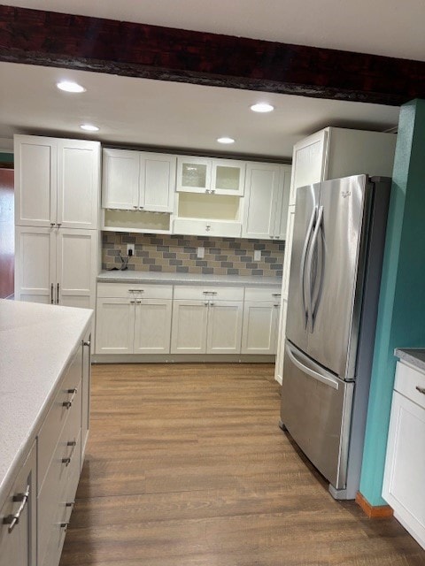 kitchen with backsplash, light wood-type flooring, and stainless steel fridge